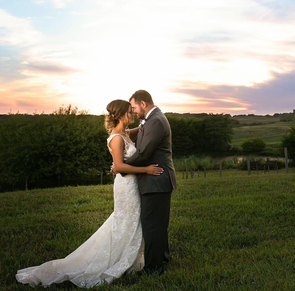 Bride and groom embracing at sunset