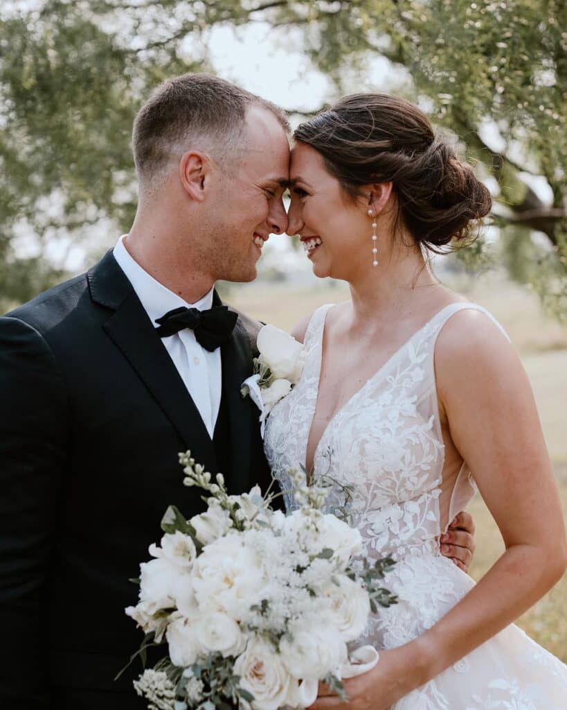 bride and groom touching noses and smiling 